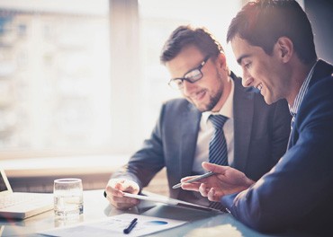 Two men looking at a device