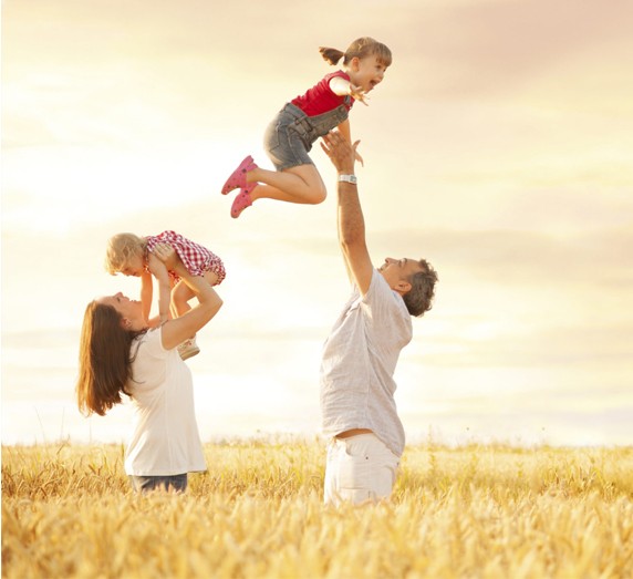 Parents playing with their kids in the field  