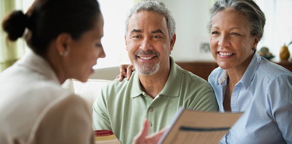 A woman talking to an old couple  