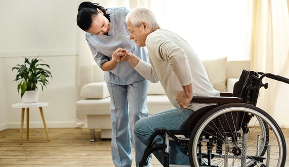 A woman helping an old man stand