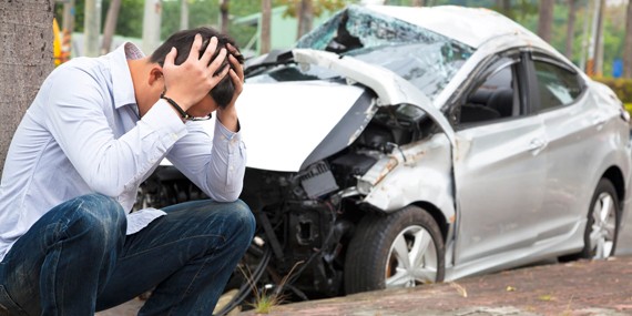 A man next to a destroyed car