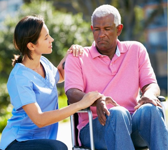 A woman talking to a black man on a wheelchair  